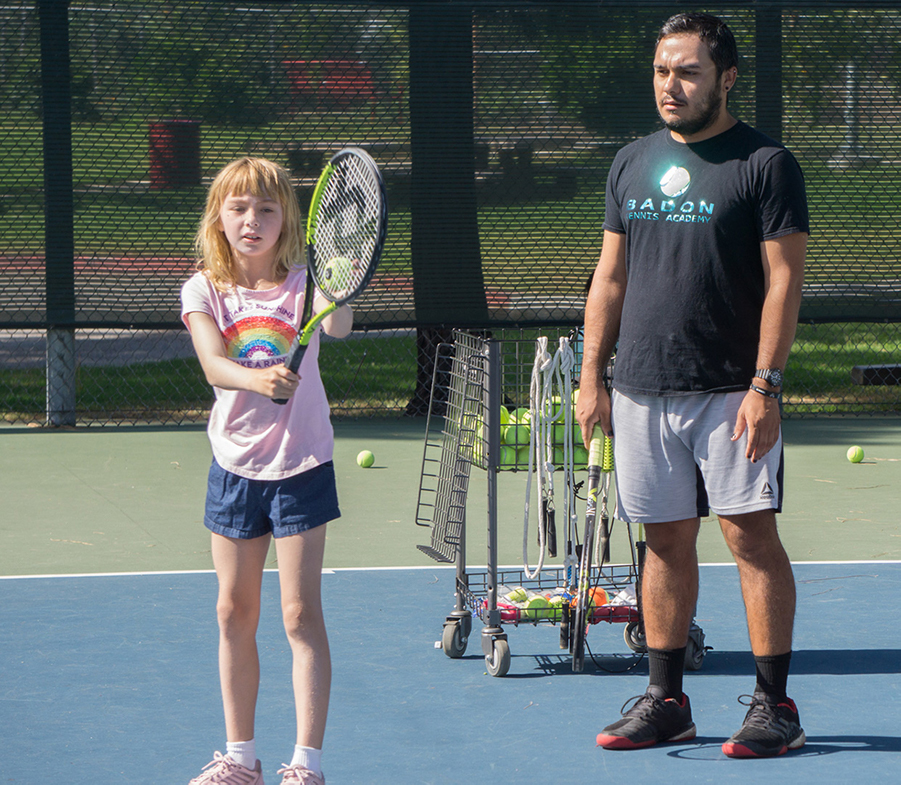 Gerald Sawyer teaching girl tennis on court