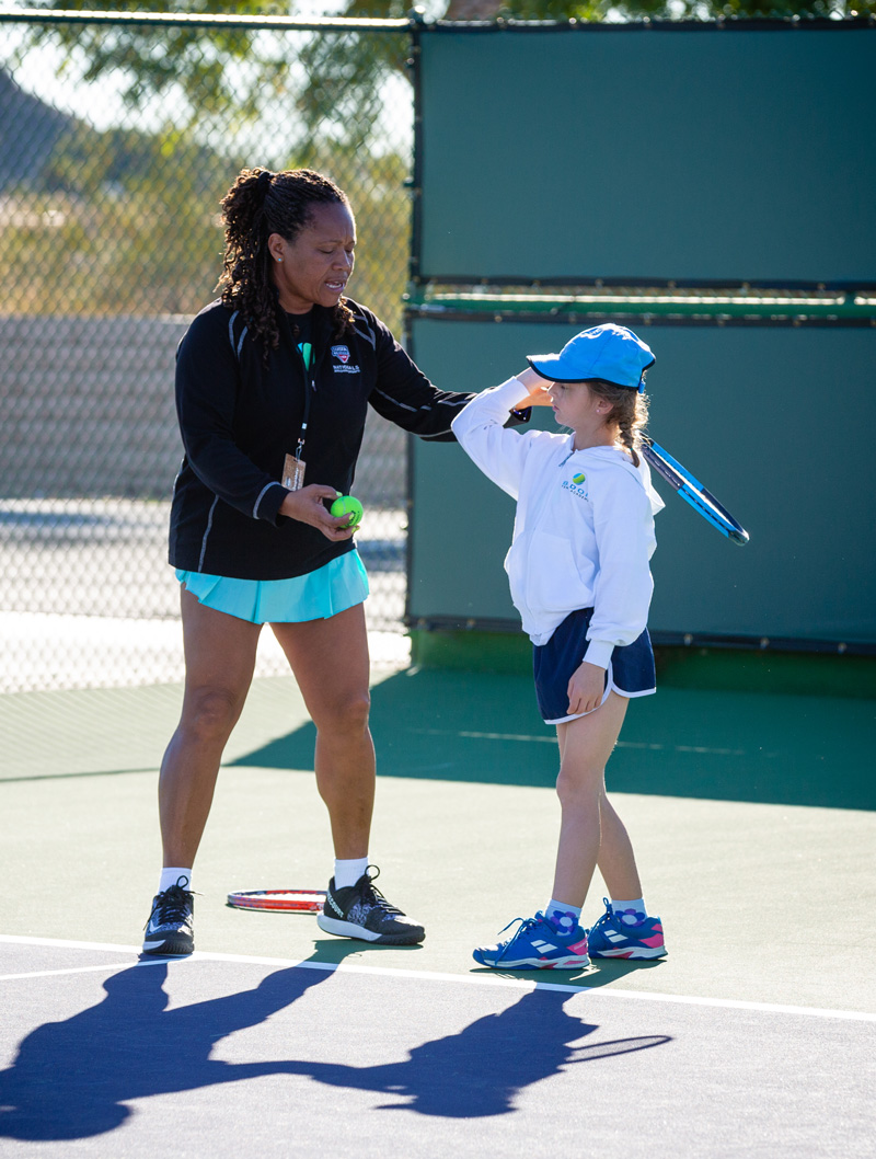 Veronica Badon coaching a student on tennis court at Indian Wells